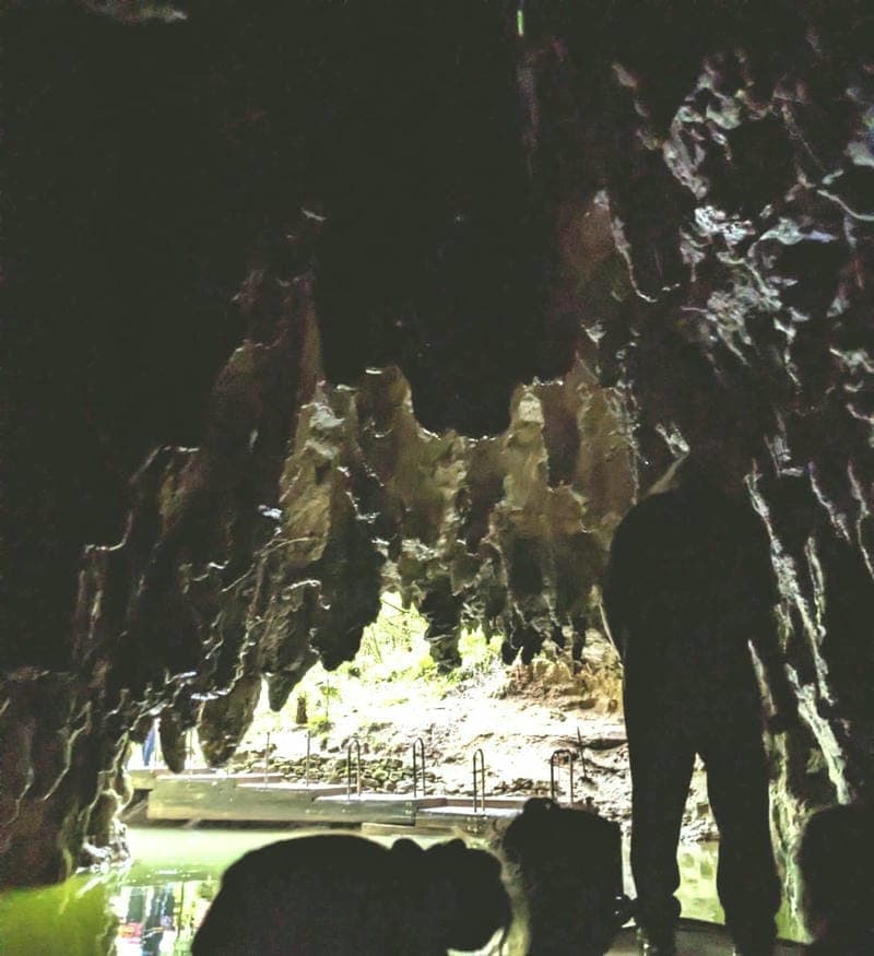 dimly lit waitomo cave with jagged rock formations